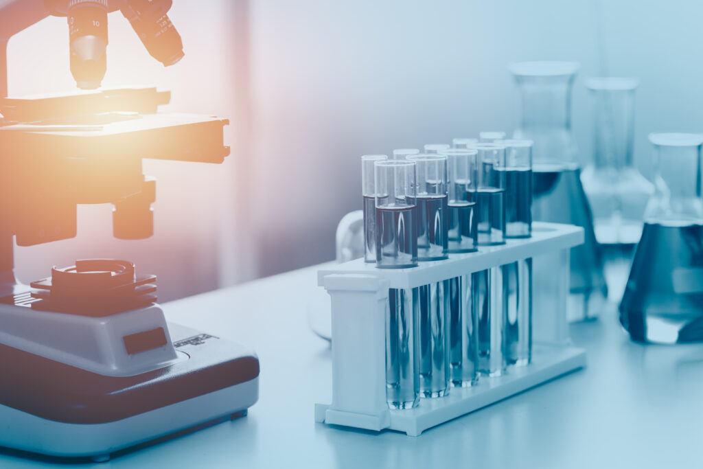 Microscope and glassware in a laboratory; illustrative stock photograph, not a NOVA facility.